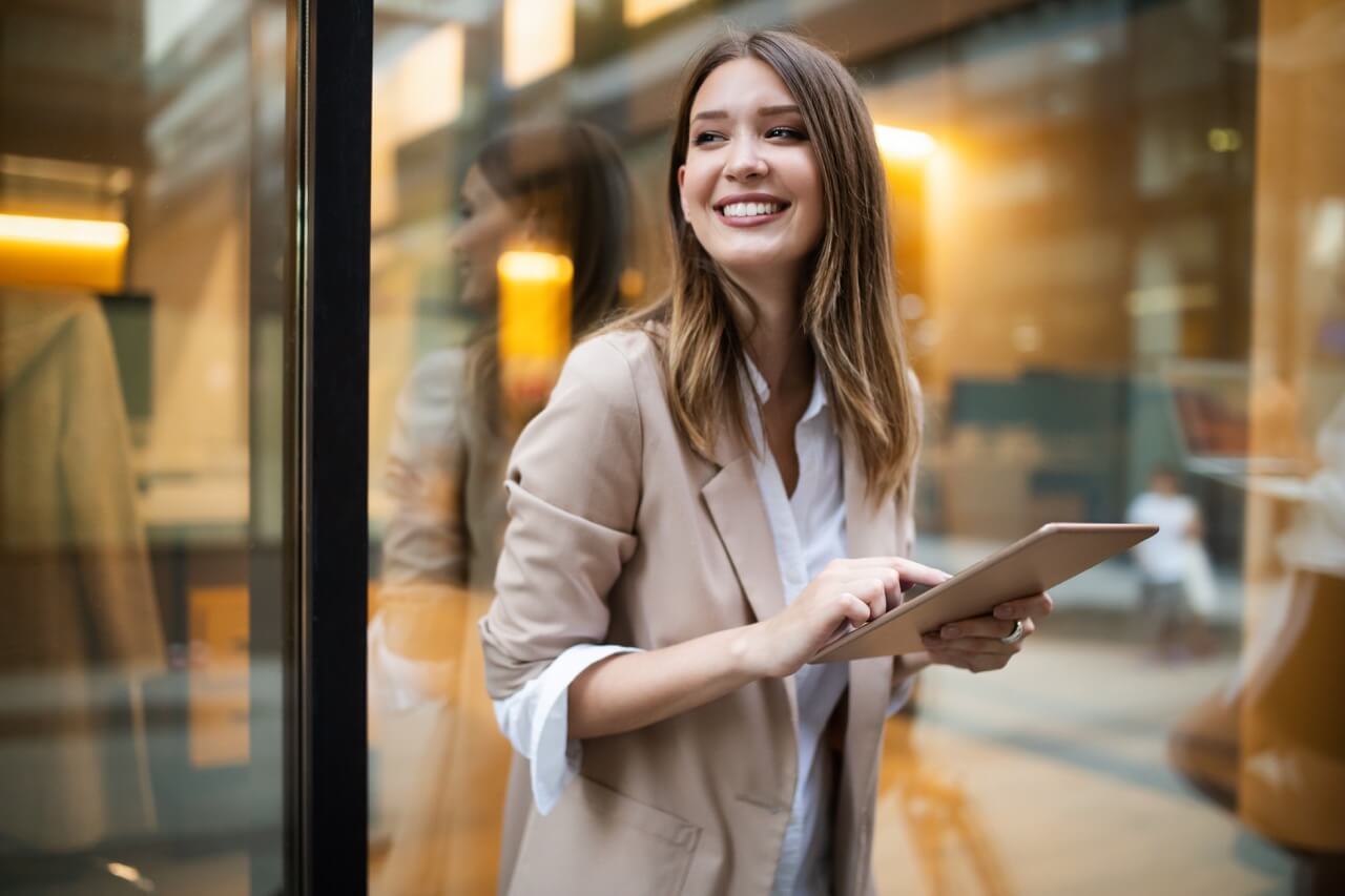 Urban happy business woman using tablet computer and working